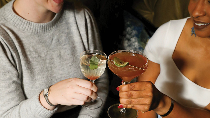 two women clicking cocktail glasses